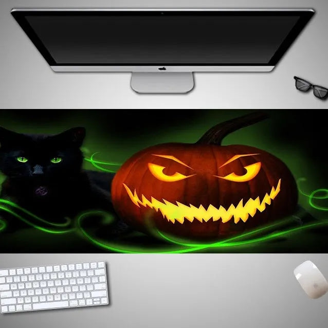 Oversized rectangular Halloween-themed mouse pad on a desk, showing non-slip rubber cloth base.