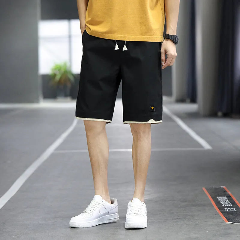 Loose fit casual shorts in green, shown on a model, featuring a straight leg and elasticated waist.