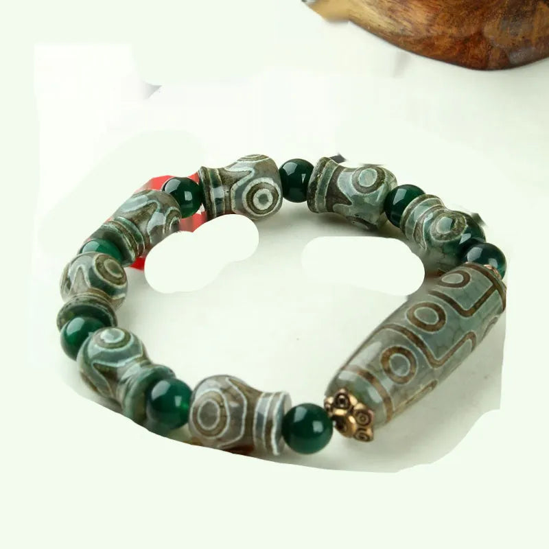 Distressed agate Tibet bead bracelet with three-eye motifs and multiple traditional bead styles on wrist