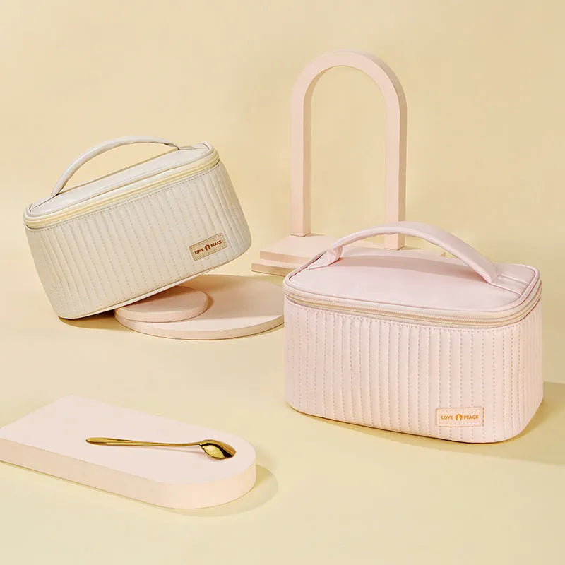 Open-top pink cake-style makeup bag made from PU leather on a table.