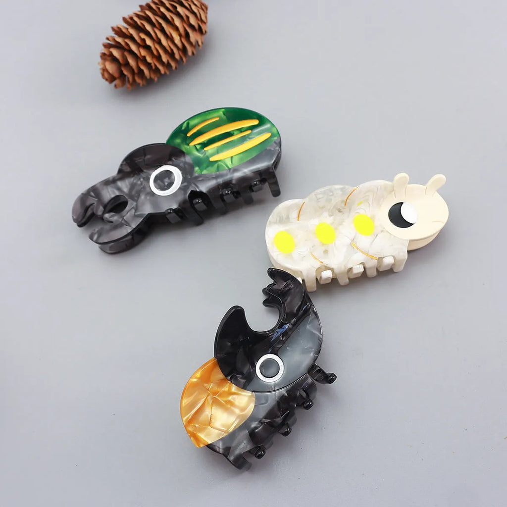 Handmade cellulose acetate Beetle Grip educational tool showing cartoon beetle and caterpillar designs