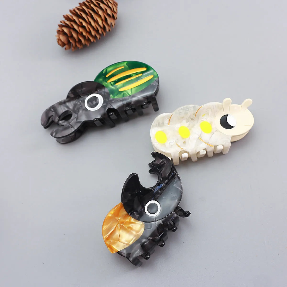 Handmade cellulose acetate Beetle Grip educational tool showing cartoon beetle and caterpillar designs