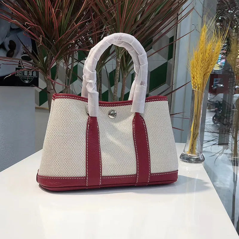 Women's canvas and genuine leather bucket tote bag with crossbody strap shown in black, brown, grey, or red.