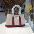 Women's canvas and genuine leather bucket tote bag with crossbody strap shown in black, brown, grey, or red.