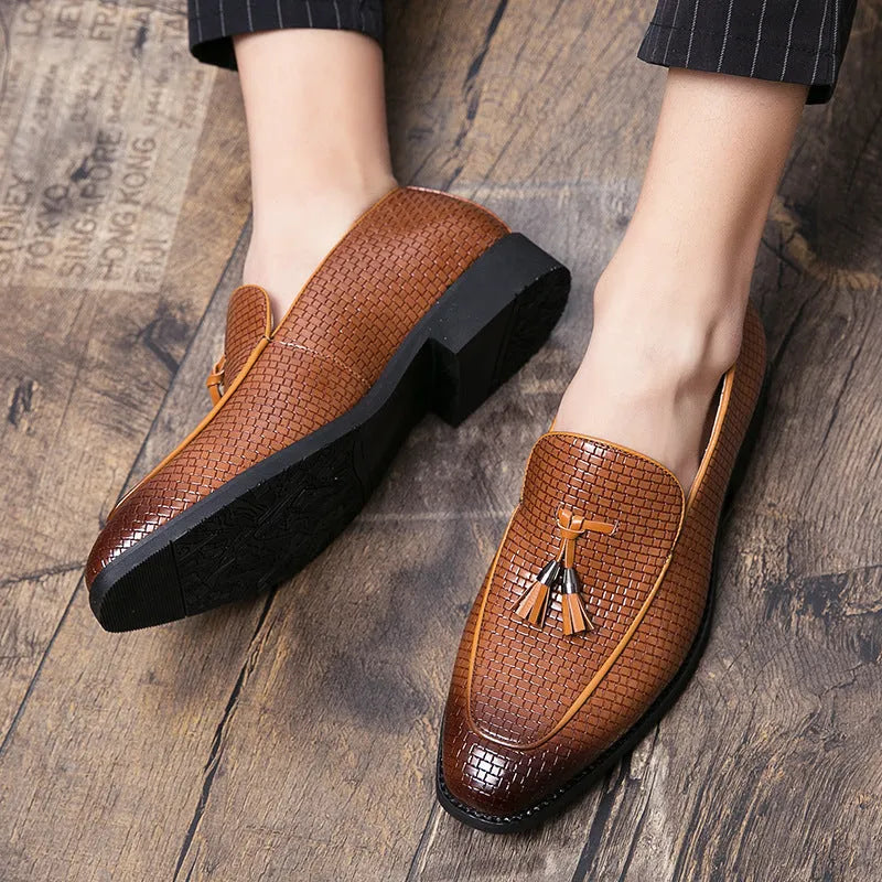 Men's black pointed toe slip-on shoes with a tassel detail on the front.