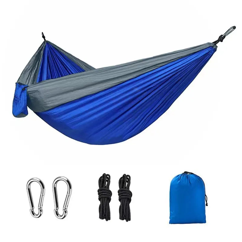 Blue and grey parachute nylon outdoor hammock hung between trees, showing its spacious 270cm length.