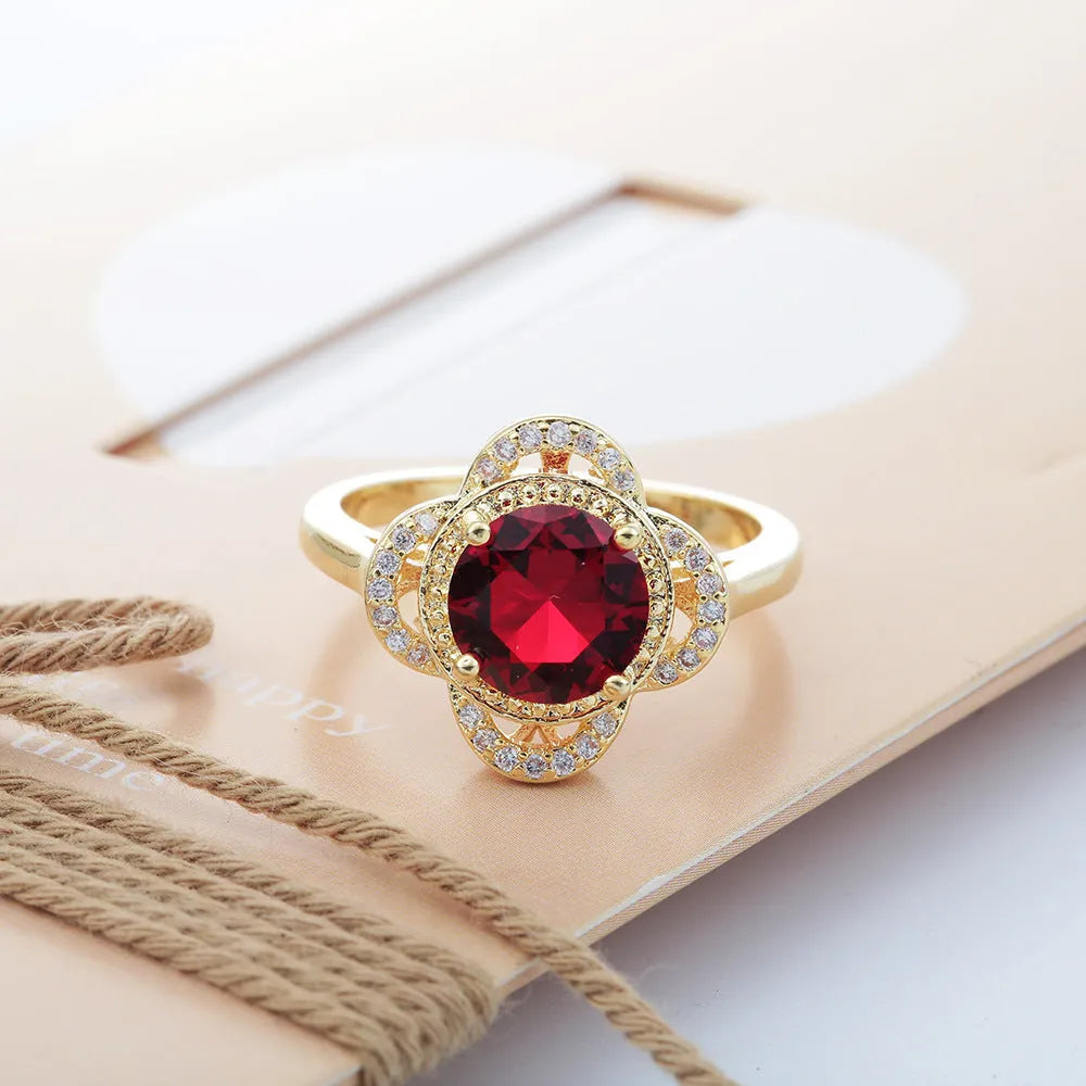 Copper fruit-shaped ring with a zircon stone inlay on a hand.