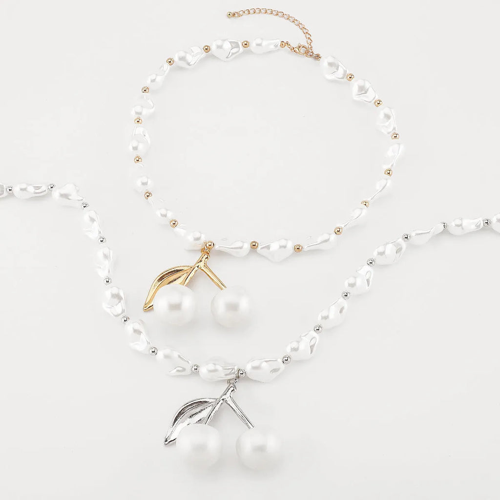 Women's adjustable pearl chain necklace with a geometric cherry fruit alloy pendant in gold colour.