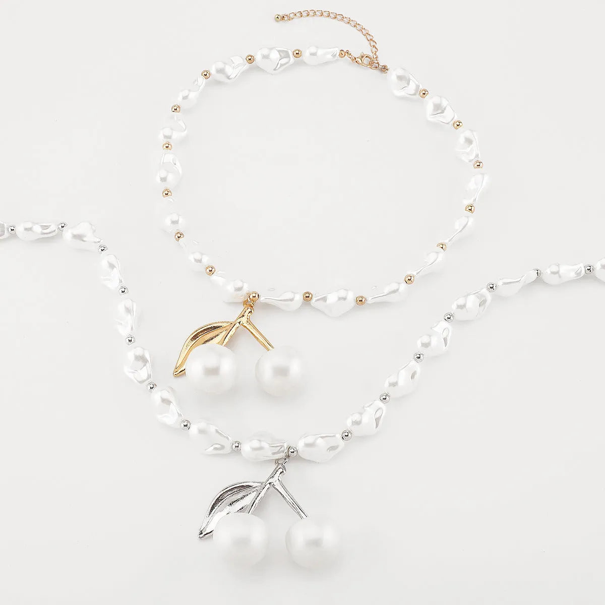 Women's adjustable pearl chain necklace with a geometric cherry fruit alloy pendant in gold colour.