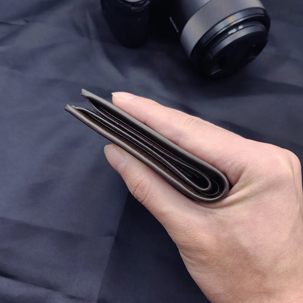 Men's leather wallet with a zipper closure, presented as a gift.