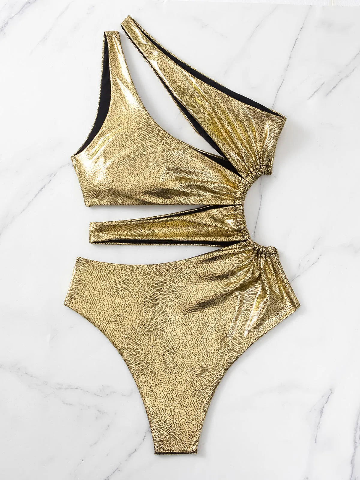 Women's solid gold backless one-piece swimsuit on a model.