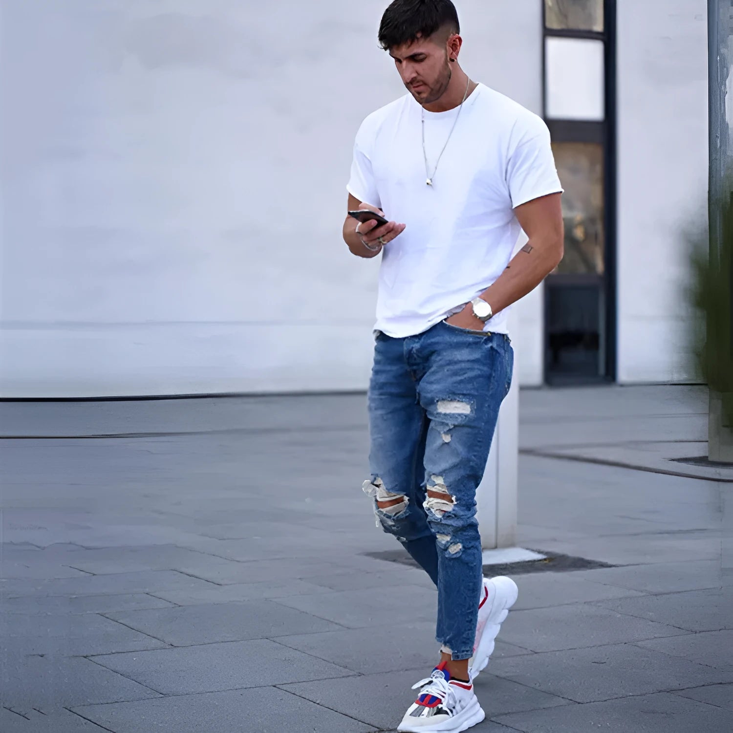 Men's deep blue jeans with hole detail showing cotton fabric texture and contemporary styling