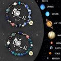 Two natural stone beaded bracelets with zodiac sign charms on a wooden surface.