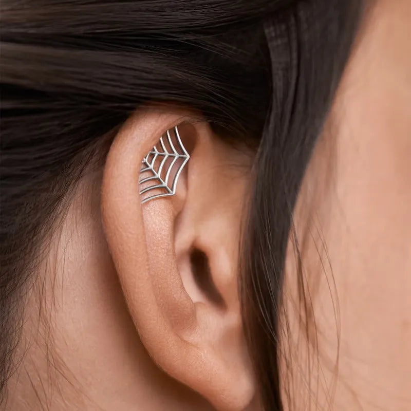 Geometric spider web stud earrings in gold and silver electroplated metal.