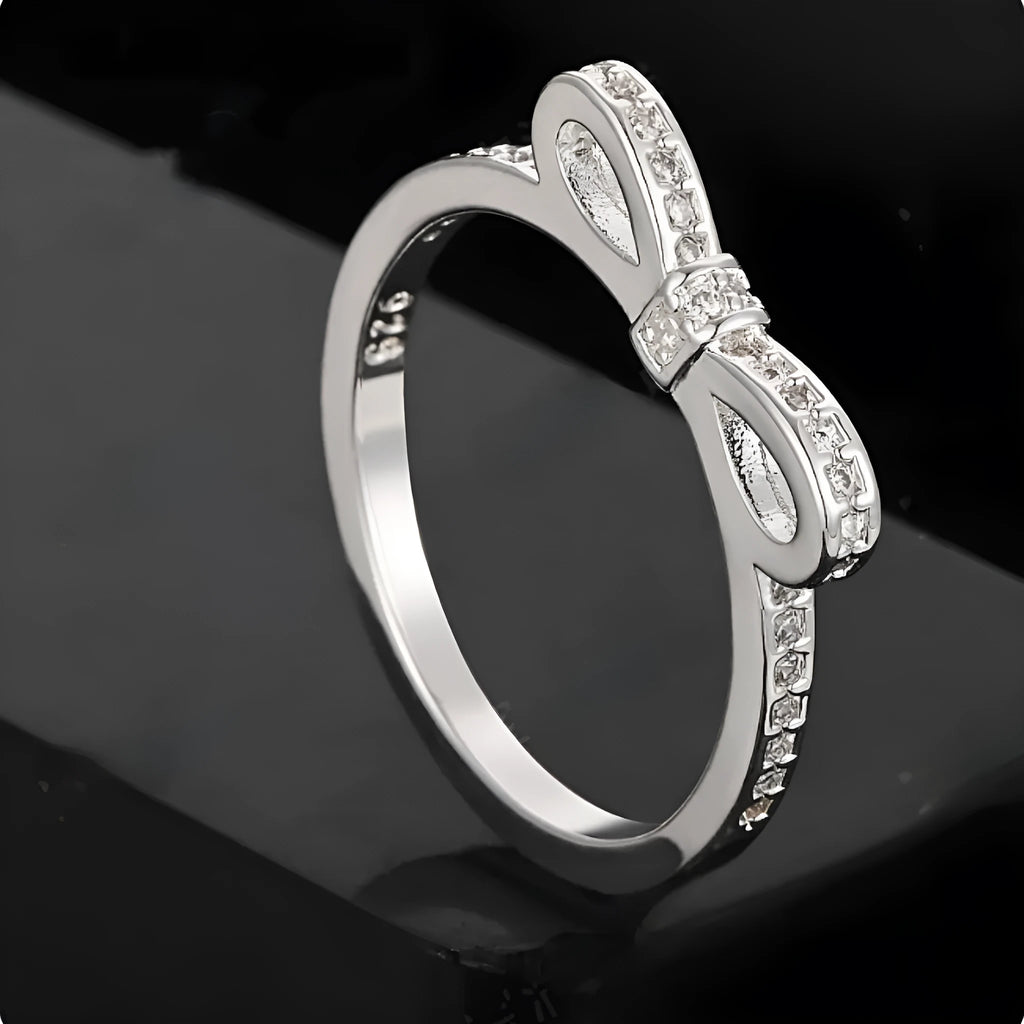 Silver electroplated ring with a bow shape design set with rhinestones and zircon crystals.