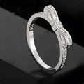 Silver electroplated ring with a bow shape design set with rhinestones and zircon crystals.