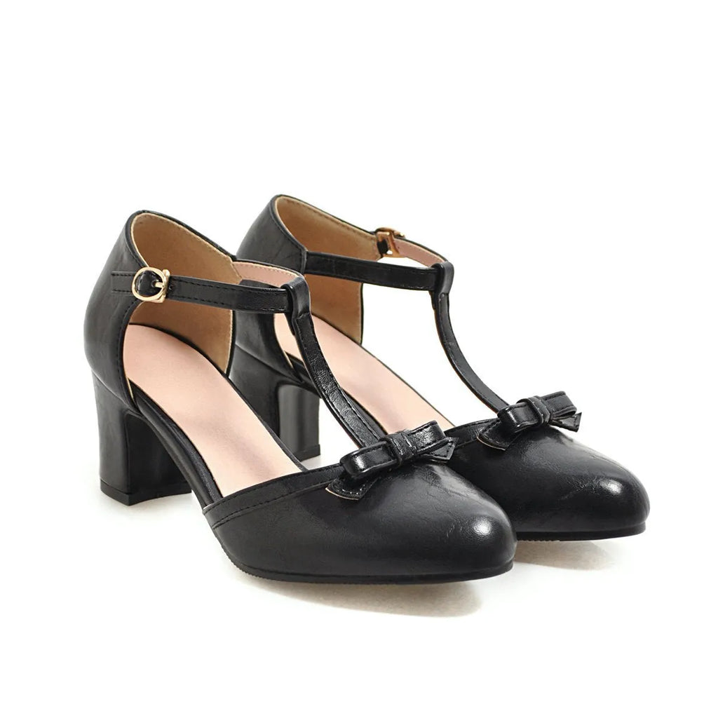 Women's apricot coloured chunky heel sandals with a bow decoration and buckle strap.