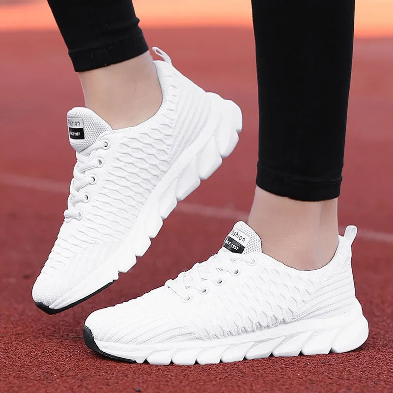 Women's running shoes with fly weave upper in black, pink, or white, showing wear-resistant outsole.