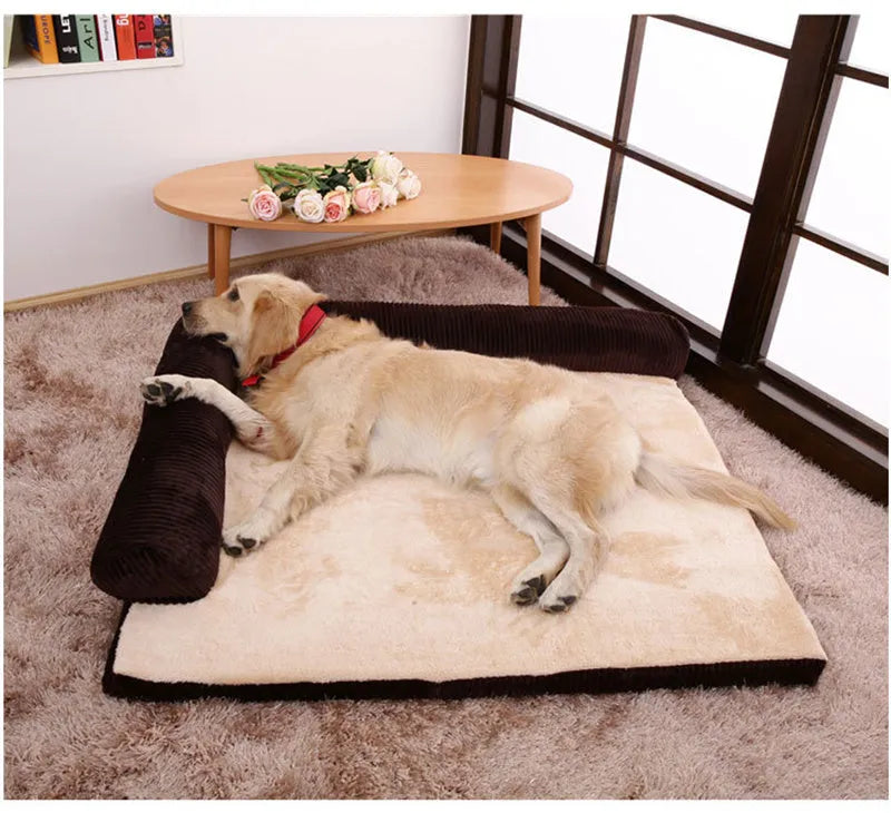 Grey corduroy dog sofa bed with raised sides and a non-slip base on a wooden floor.