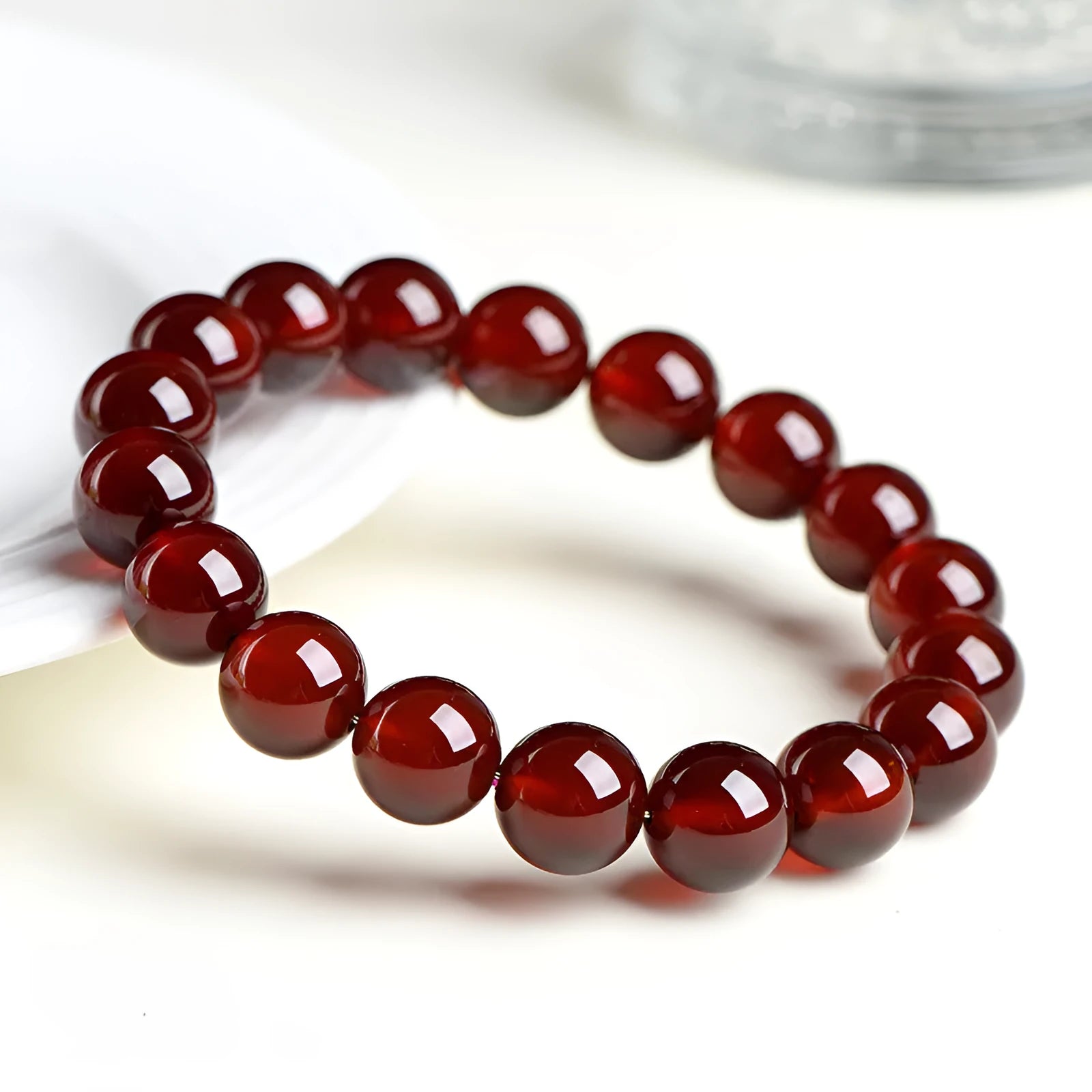 Natural orange red garnet crystal ball bracelet with a traditional metal Ruyi-style clasp.