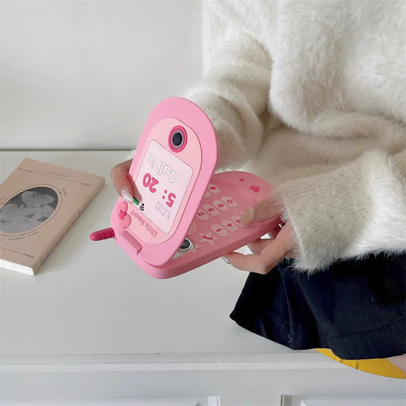 Light pink silicone flip phone shape case with mirror for iPhone, showing cute cartoon style.