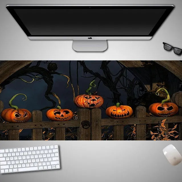 Oversized rectangular Halloween-themed mouse pad on a desk, showing non-slip rubber cloth base.