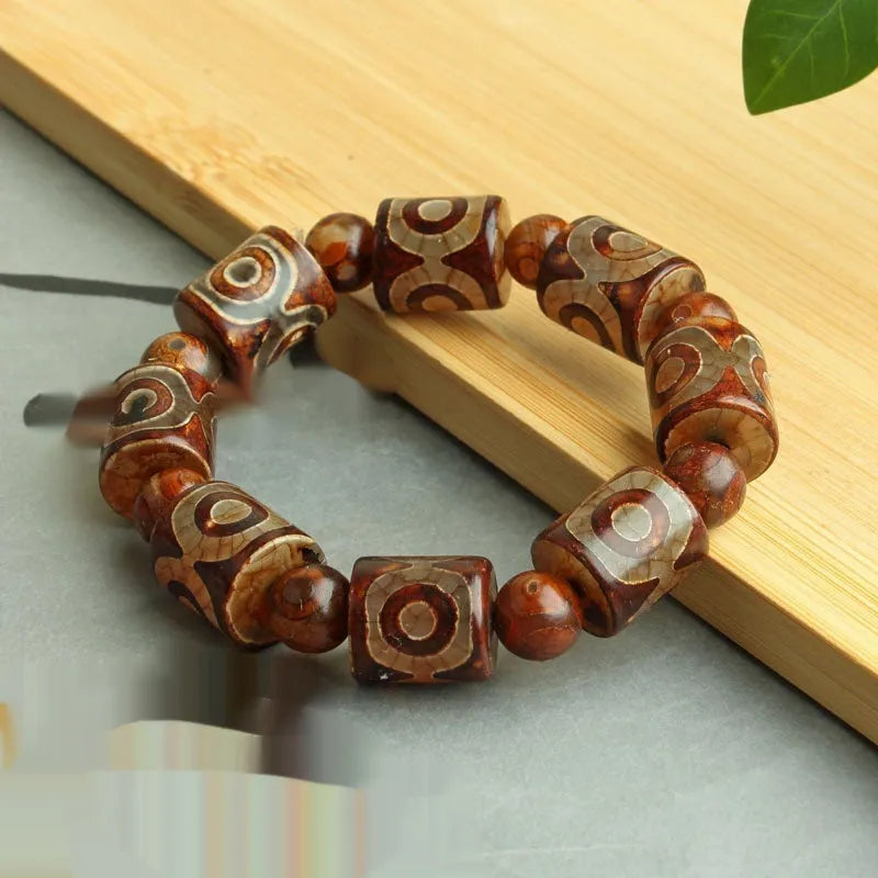 Distressed agate Tibet bead bracelet with three-eye motifs and multiple traditional bead styles on wrist