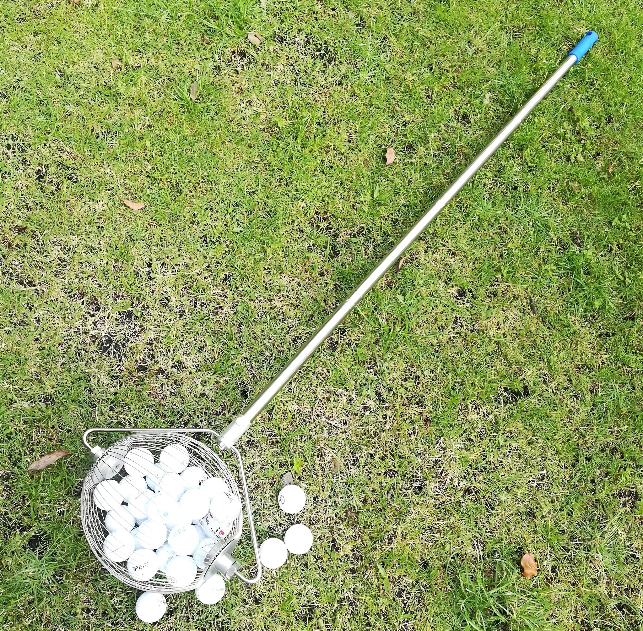 Metallic coloured golf ball picker made from stainless steel on a green