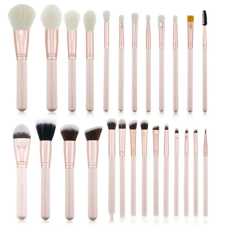 26 pink makeup brushes with wooden handles laid out next to a matching storage bag.