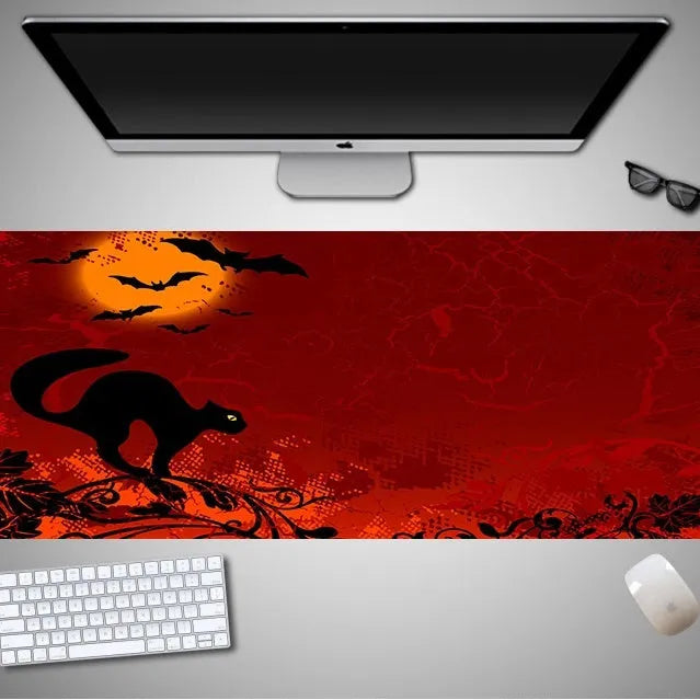 Oversized rectangular Halloween-themed mouse pad on a desk, showing non-slip rubber cloth base.