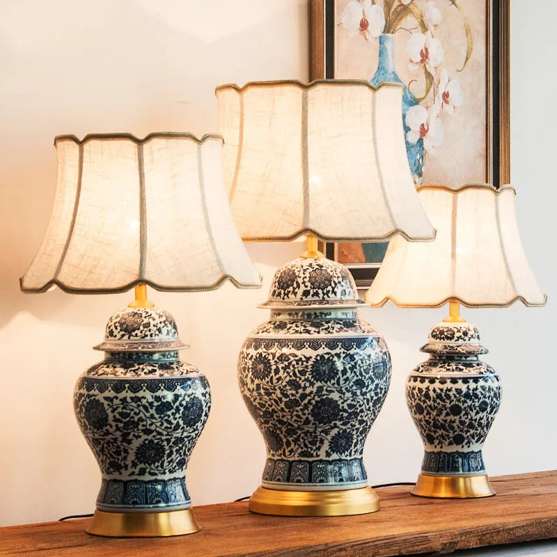 Chinese style blue and white porcelain table lamp with handmade ceramic base and cloth shade on bedside table