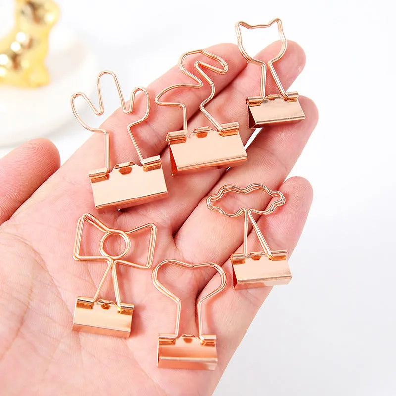 Gold-coloured metal office clip in decorative bow shape design