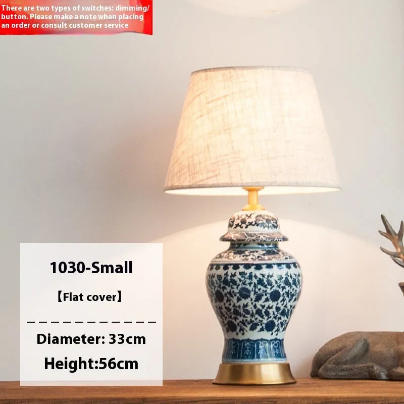 Chinese style blue and white porcelain table lamp with handmade ceramic base and cloth shade on bedside table