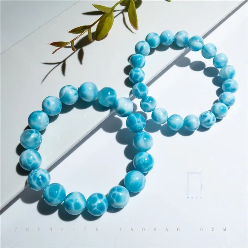 Blue Maillard-style bracelet with bodhi beads, natural crystal stone, and pearl accents on a wrist.