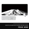 Oversized gaming mouse pad with graphic design on a desk with keyboard.