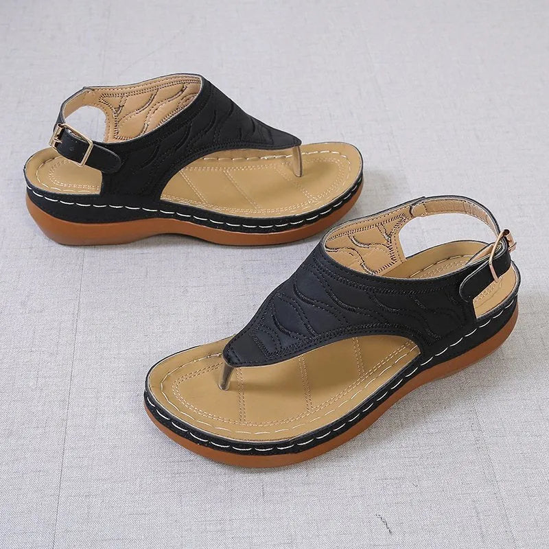 Women's wedge heel flip flop sandals with an adjustable back buckle strap in black.