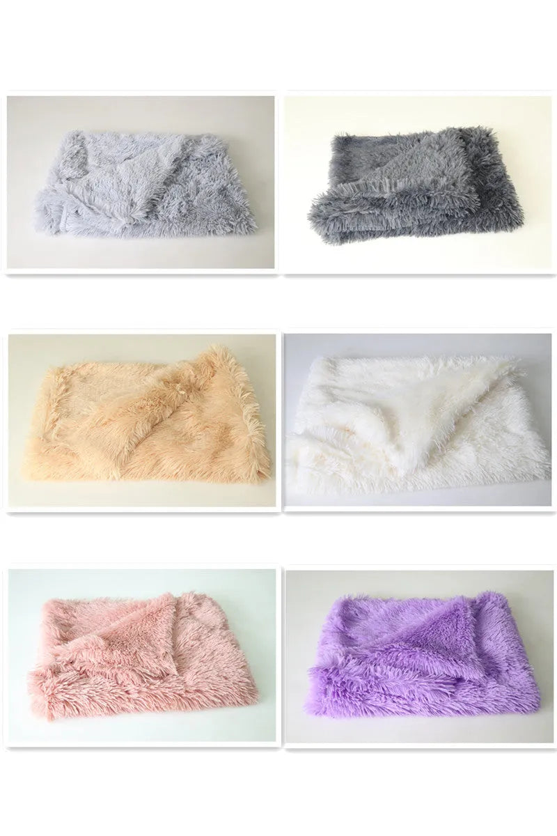 Soft grey plush pet blanket for dogs shown on a floor next to a kennel.