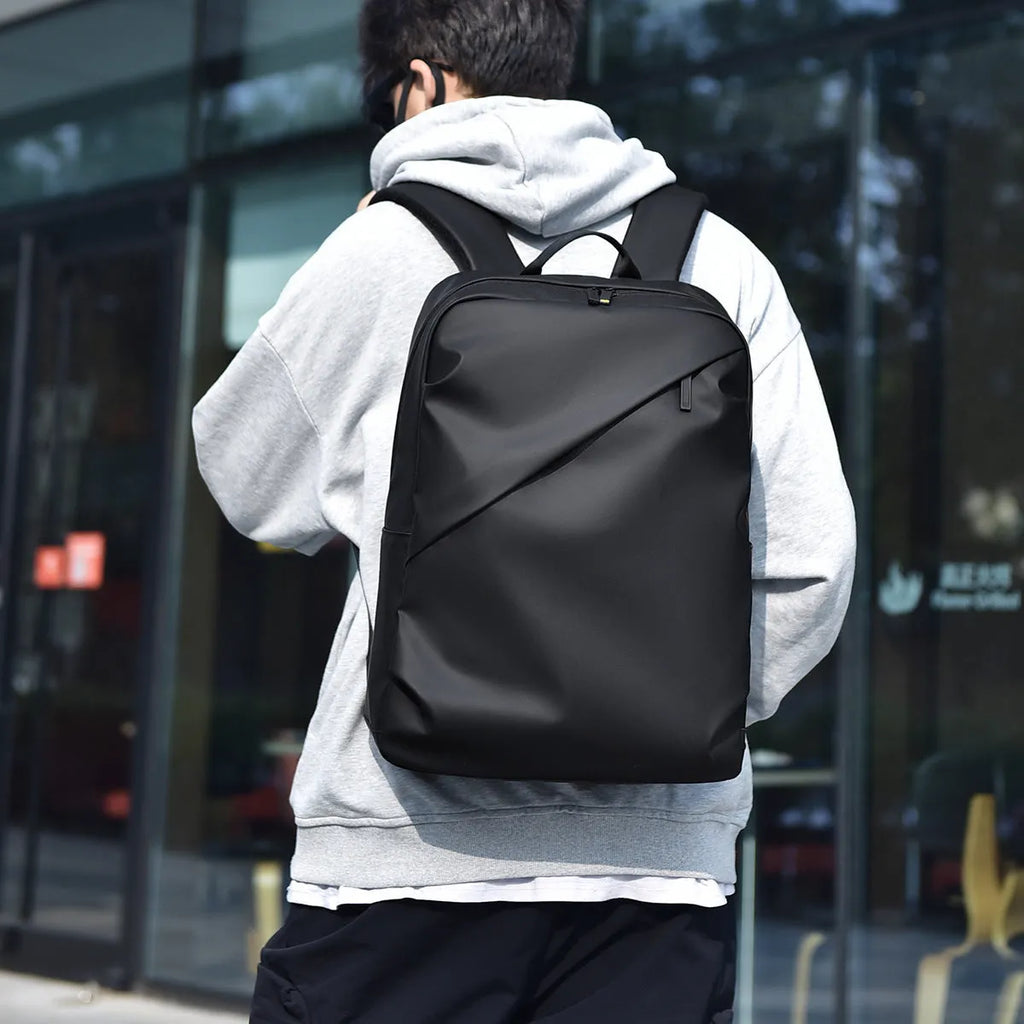 Large black waterproof PU backpack with sewing thread details and separate laptop bag