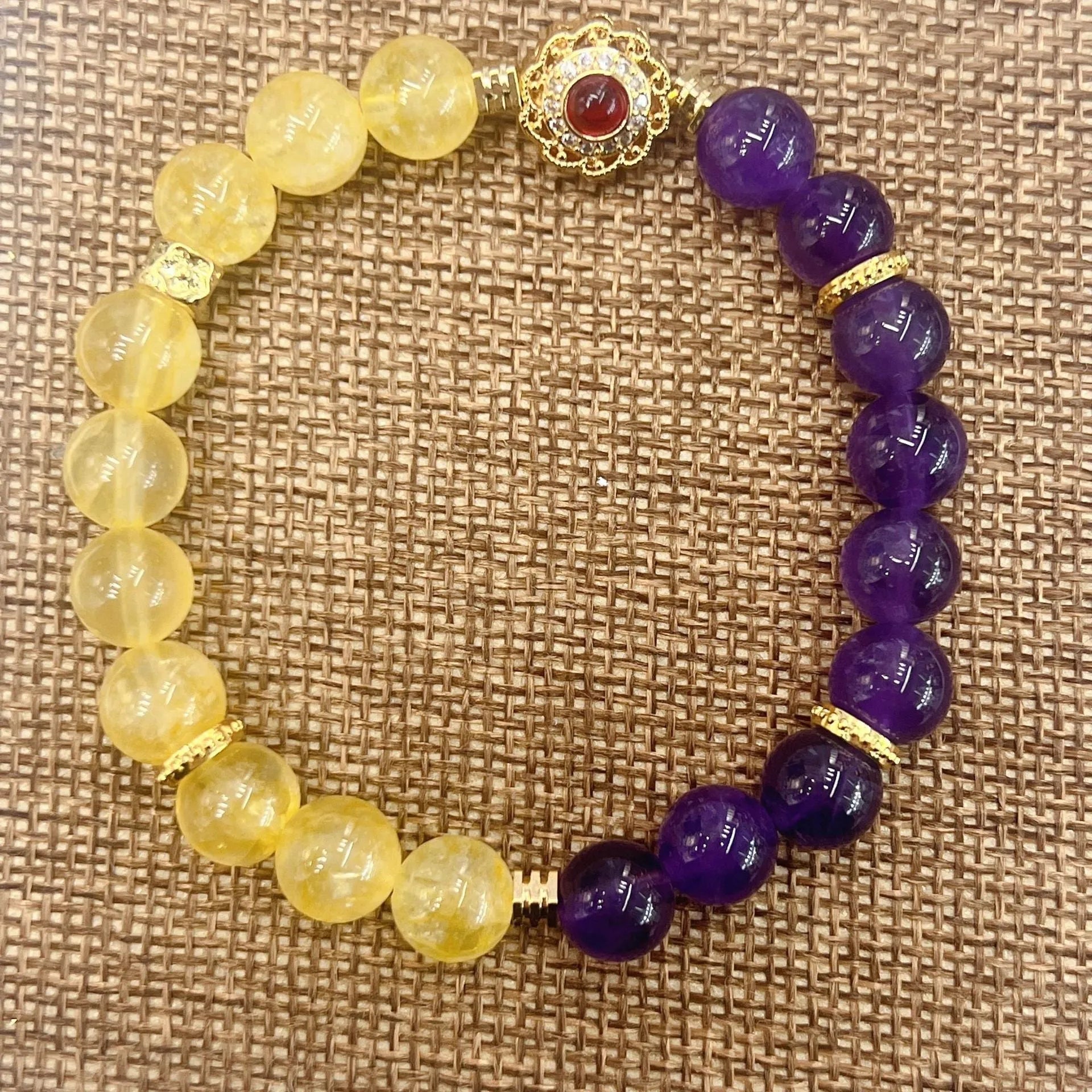 Handmade yellow and purple crystal bracelet for women on a wrist.