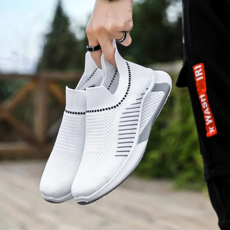 Men's black and white mesh slip-on sneakers with striped design and flat sole.