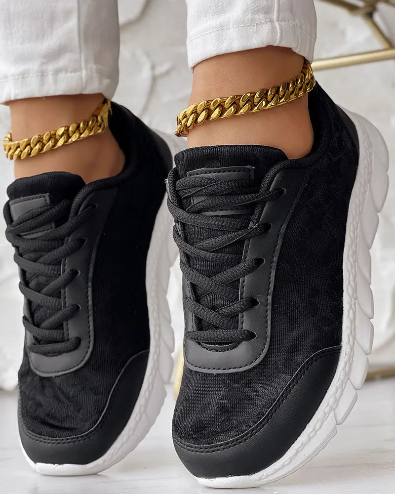 Women's white canvas running shoes with a flat sole and round toe on a neutral background.