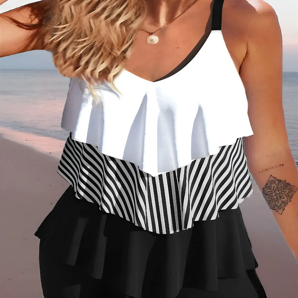 Women's sleeveless backless spaghetti strap bikini swimsuit with ruffle detail and split briefs.