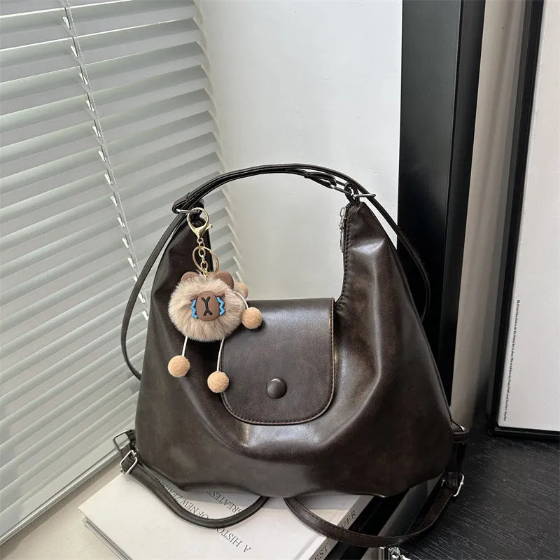 Textured PU leather commuter backpack with single shoulder strap and internal mobile phone pocket