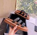 Women's black Roman-style sandal slippers made of glossy patent leather and soft sheepskin.