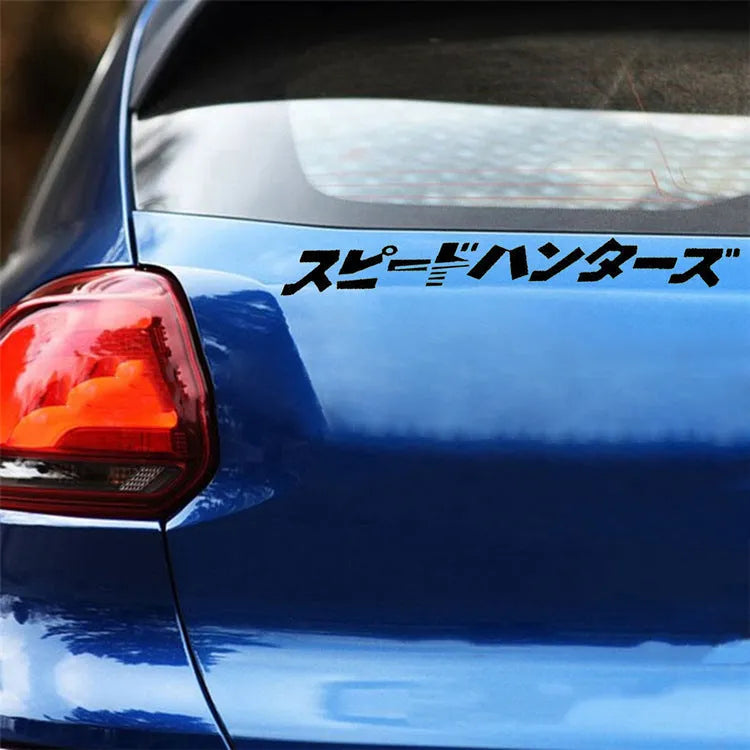 Black and white 35x35cm square reflective Japanese car sticker on a vehicle window.