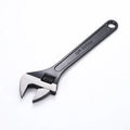 Stainless steel adjustable open-end wrench on a workbench