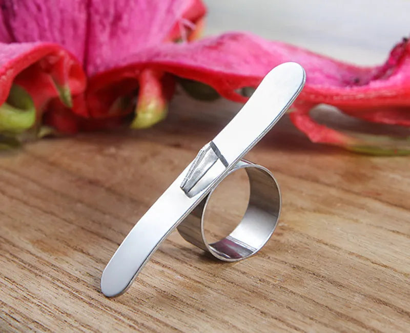 Silver stainless steel orange peeler ring on a citrus fruit