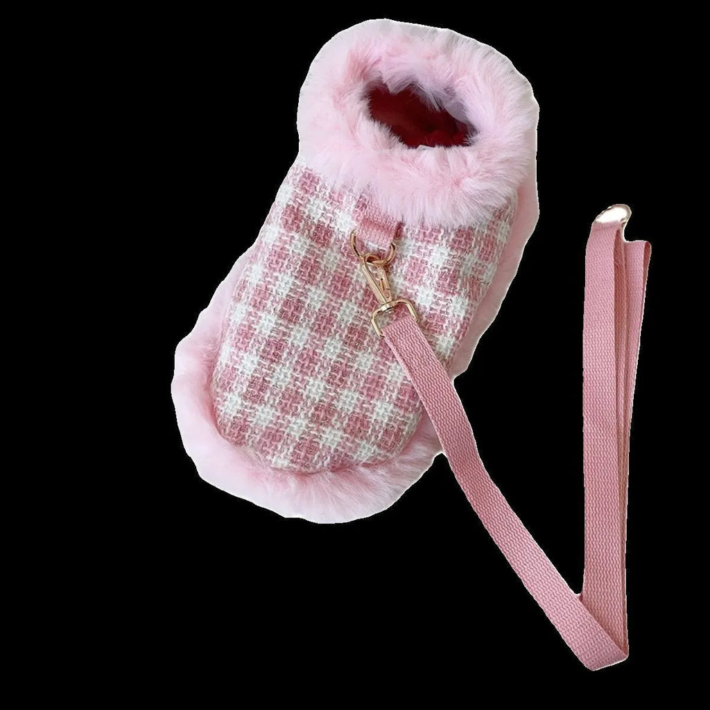 Cat wearing pink beret and matching cloak costume with hand-holding rope