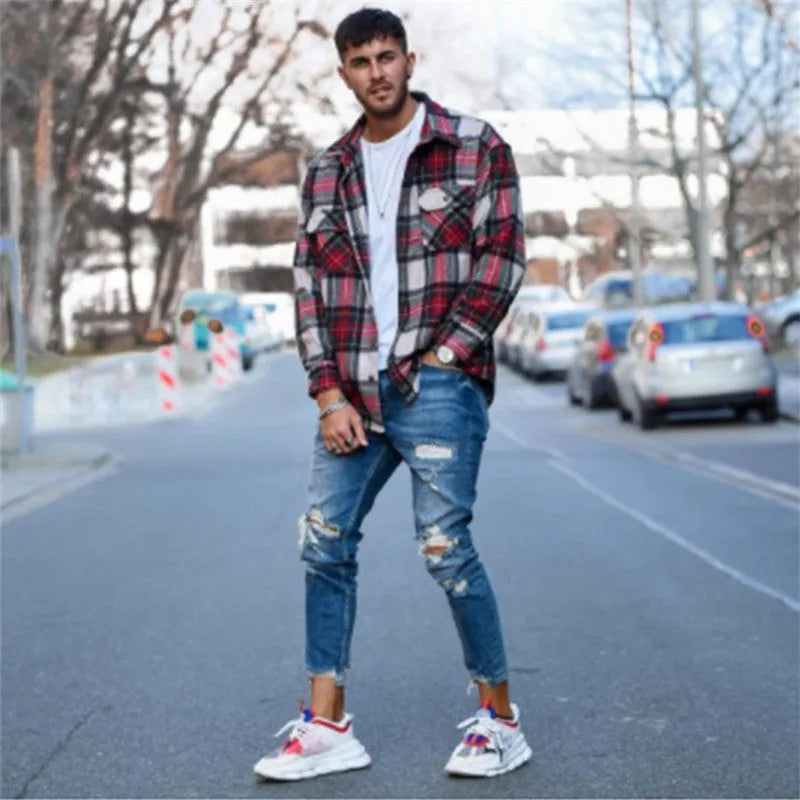 Men's deep blue jeans with hole detail showing cotton fabric texture and contemporary styling