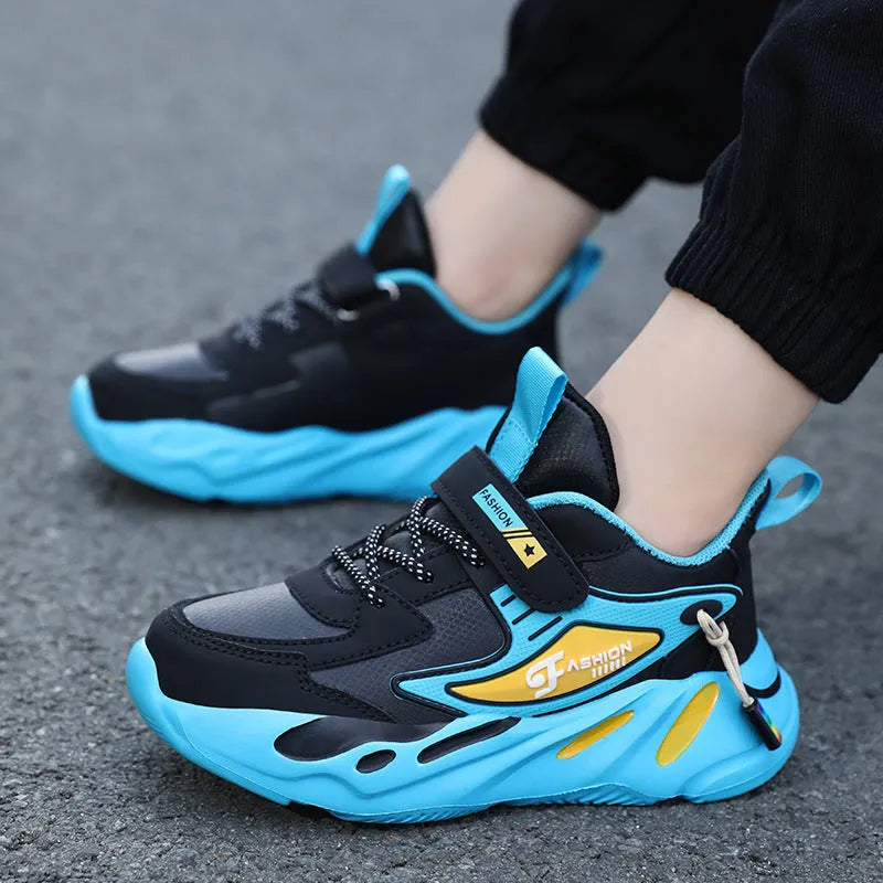Boys' blue and black platform sports running shoes with Velcro strap on a hard ground surface.